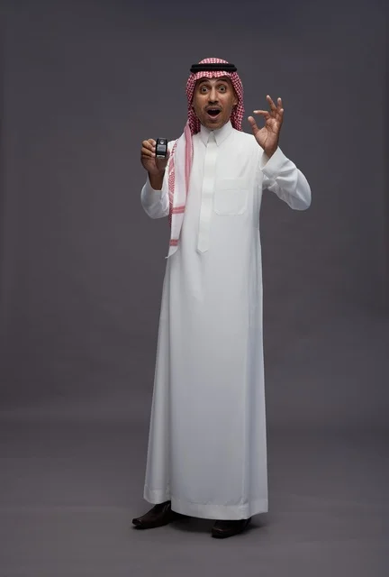 رجل سعودي بالزي التقليدي يحمل مفتاح سيارة
