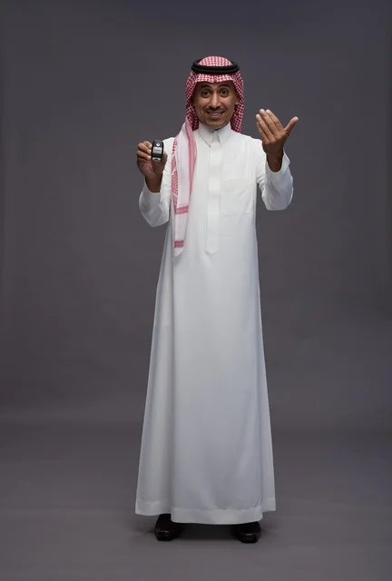 Saudi Man in Traditional Dress Holding Car Key