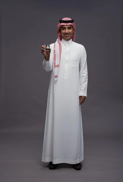 Saudi Man in Traditional Dress Holding a Car Key Remote