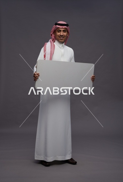 رجل سعودي يحمل لوحة بيضاء فارغة للعرض