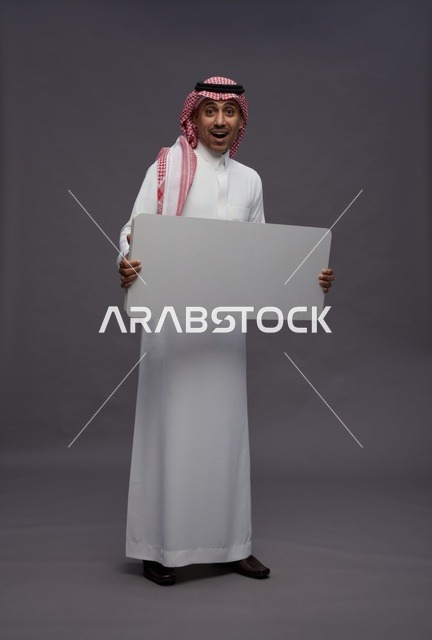 رجل سعودي يحمل لوحة بيضاء فارغة للعرض