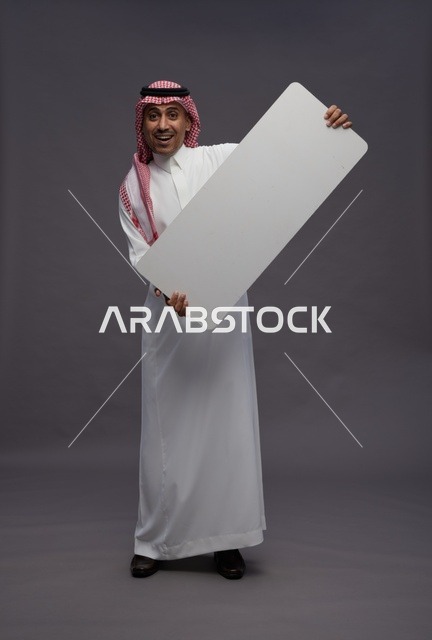 رجل سعودي يحمل لوحة بيضاء فارغة للعرض