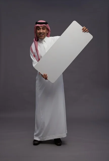 رجل سعودي يحمل لوحة بيضاء فارغة للعرض