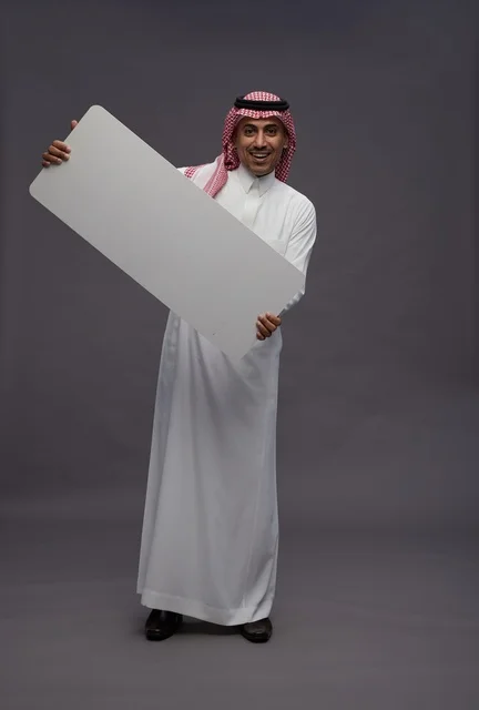 رجل سعودي يحمل لوحة بيضاء فارغة للعرض