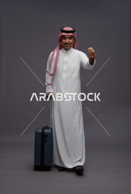 رجل سعودي بالزي التقليدي مع حقيبة سفر