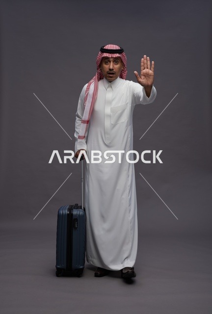 Saudi Man in Traditional Dress with Suitcase Stop Gesture