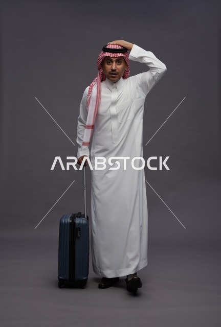 رجل سعودي بالزي التقليدي يحمل حقيبة سفر