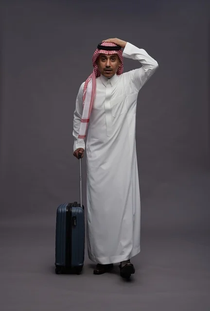 رجل سعودي بالزي التقليدي يحمل حقيبة سفر