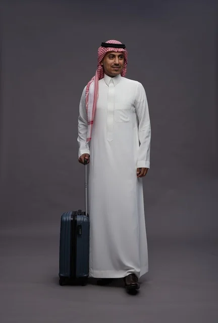 رجل سعودي يحمل حقيبة سفر بالزي التقليدي