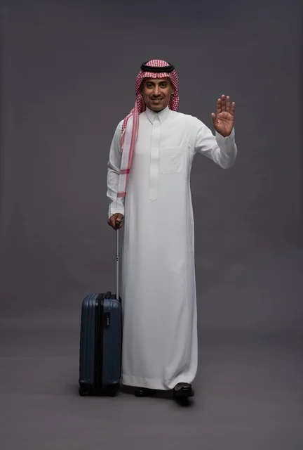 Saudi Man in Traditional Thobe with Suitcase Waving