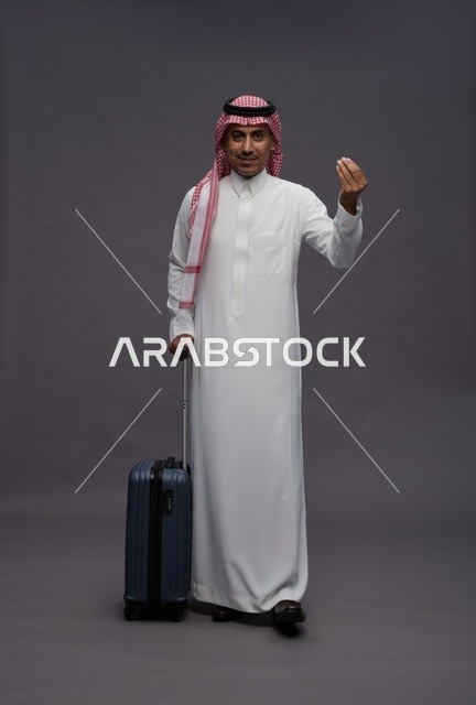 رجل سعودي بالزي التقليدي مع حقيبة سفر