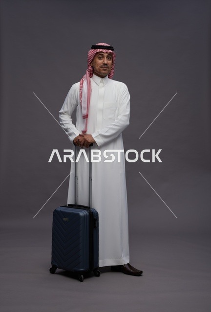 رجل سعودي بالزي التقليدي مع حقيبة سفر