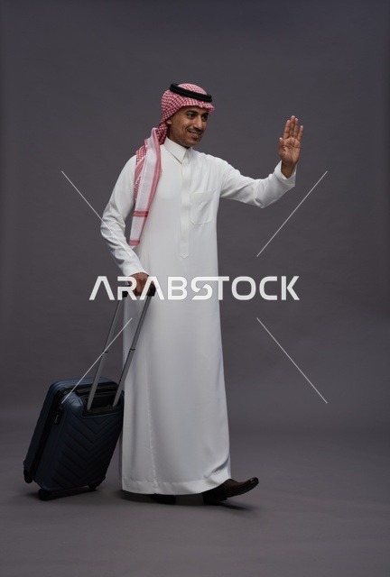رجل سعودي بالزي التقليدي يحمل حقيبة سفر