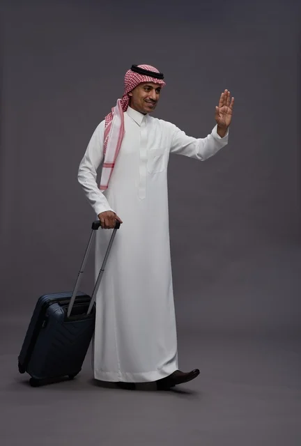 رجل سعودي بالزي التقليدي يحمل حقيبة سفر