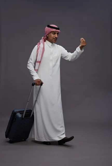 رجل سعودي بالزي التقليدي يحمل حقيبة سفر