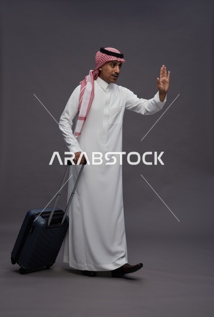 رجل سعودي بالزي التقليدي يحمل حقيبة سفر