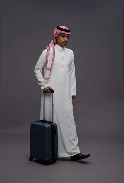 رجل سعودي بالزي التقليدي يحمل حقيبة سفر