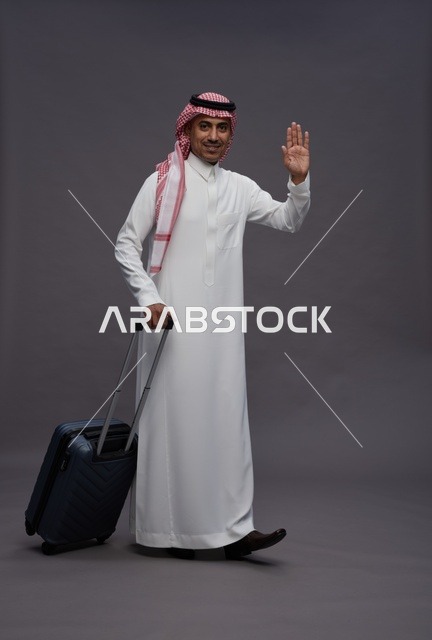 رجل سعودي بالزي التقليدي يحمل حقيبة سفر