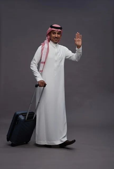 رجل سعودي بالزي التقليدي يحمل حقيبة سفر