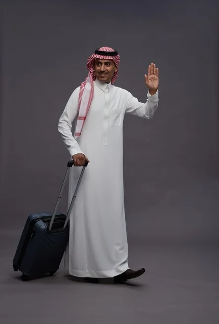 Saudi Man in Traditional Thobe Walking with Suitcase