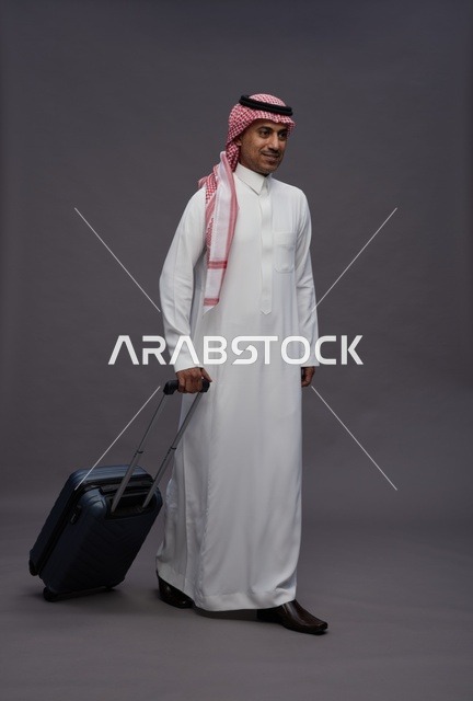 رجل سعودي يرتدي الثوب التقليدي ويحمل حقيبة سفر