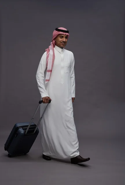 رجل سعودي بالزي التقليدي يحمل حقيبة سفر