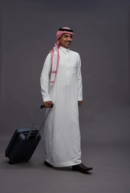 رجل سعودي بالزي التقليدي مع حقيبة سفر
