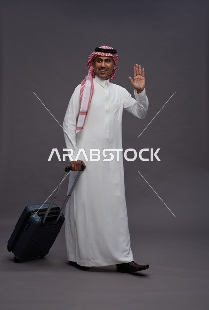 رجل سعودي بالزي التقليدي يحمل حقيبة سفر