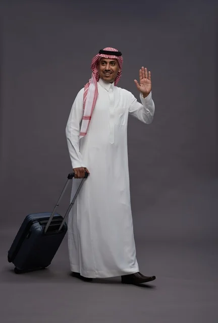 رجل سعودي بالزي التقليدي يحمل حقيبة سفر