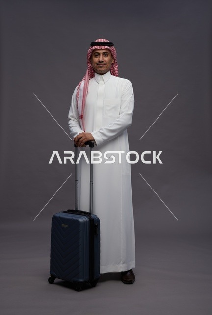 رجل سعودي بالزي التقليدي مع حقيبة سفر