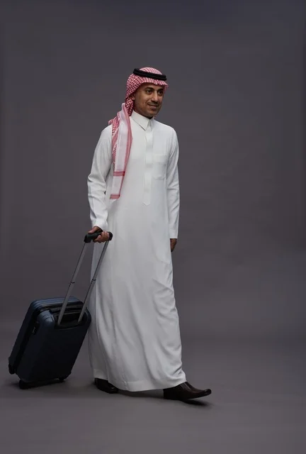رجل سعودي بالزي التقليدي يحمل حقيبة سفر