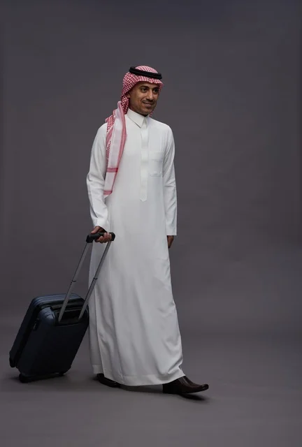 رجل سعودي بالزي التقليدي يحمل حقيبة سفر