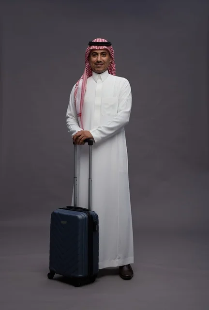 رجل سعودي بالزي التقليدي مع حقيبة سفر في الاستوديو