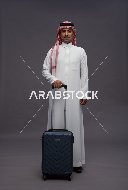 رجل سعودي بالزي التقليدي مع حقيبة سفر