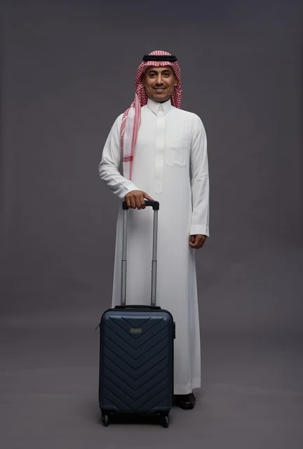 رجل سعودي بالزي التقليدي يحمل حقيبة سفر