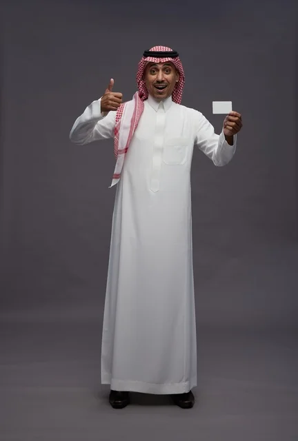 رجل سعودي يحمل بطاقة ائتمانية مع علامة الإعجاب