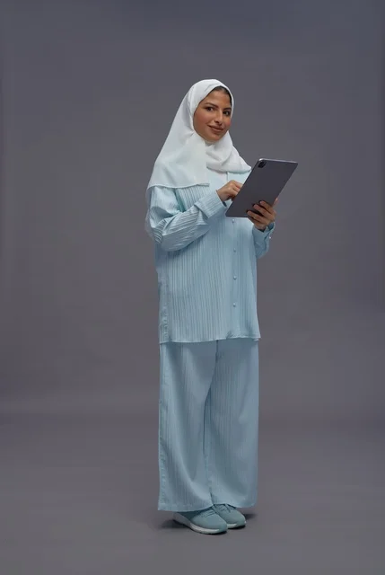 امرأة سعودية تستخدم جهاز لوحي بزي محتشم
