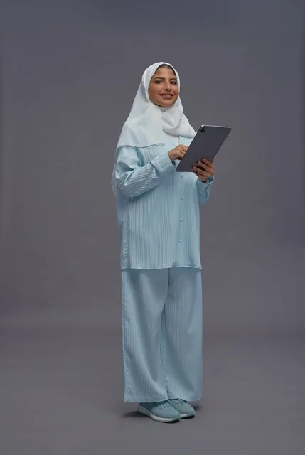 امرأة سعودية محجبة تستخدم جهاز لوحي في الاستوديو