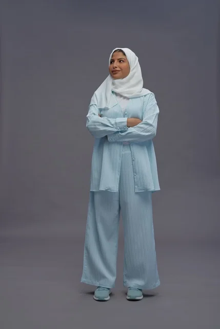 امرأة سعودية واثقة بزي كاجوال محتشم باللون الأزرق
