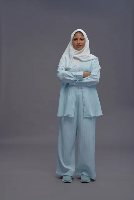 امرأة سعودية واثقة بملابس كاجوال محتشمة في الاستوديو