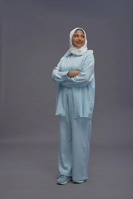 امرأة سعودية بزي كاجوال محتشم وذراعين متقاطعتين