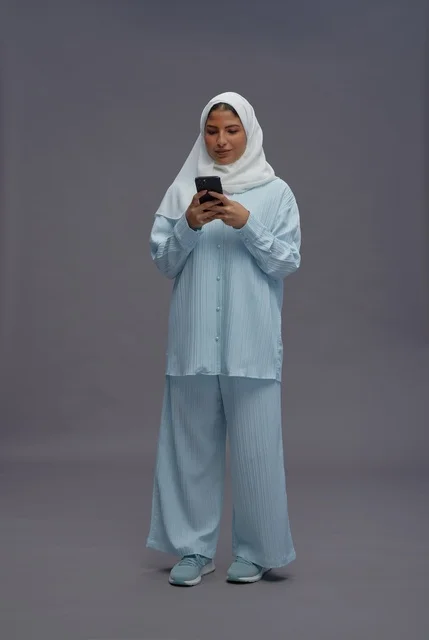 Saudi Woman in Casual Outfit Using Smartphone