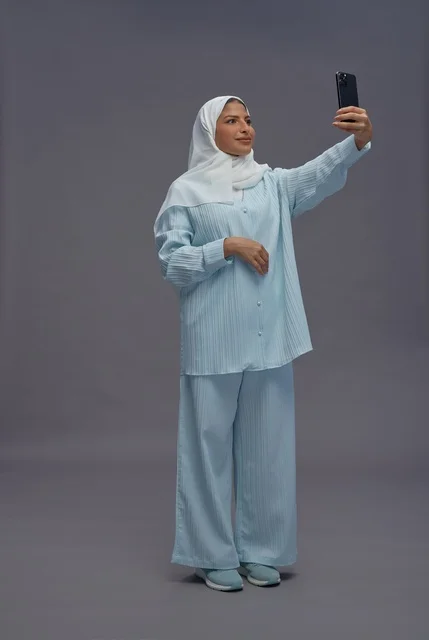 امرأة سعودية بالحجاب تلتقط سيلفي بالهاتف الذكي