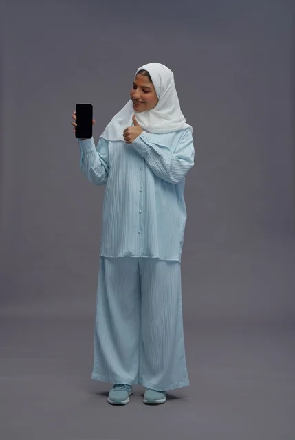 امرأة سعودية تحمل هاتف ذكي في استوديو تصوير