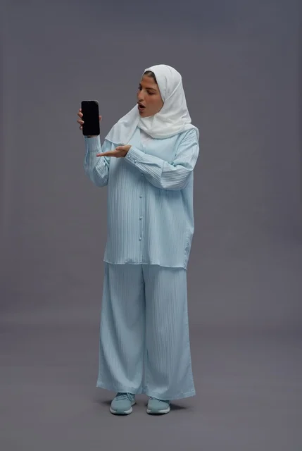 Saudi Woman Holding Smartphone on Grey Background