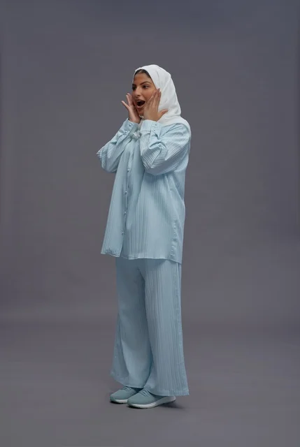 امرأة سعودية بزي كاجوال أزرق وحجاب أبيض