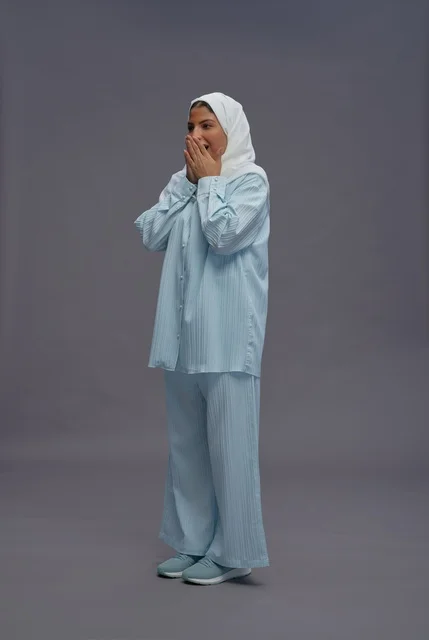 امرأة سعودية متفاجئة بملابس كاجوال وحجاب أبيض