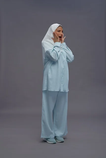 امرأة سعودية بزي كاجوال أزرق وحجاب أبيض