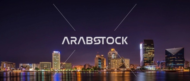 أفق مدينة دبي ومعالمها العمرانية ليلاً على الخور