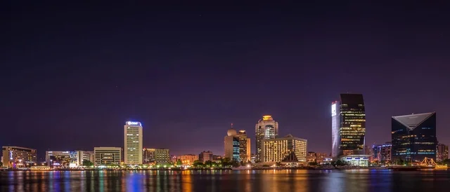 أفق مدينة دبي ومعالمها العمرانية ليلاً على الخور